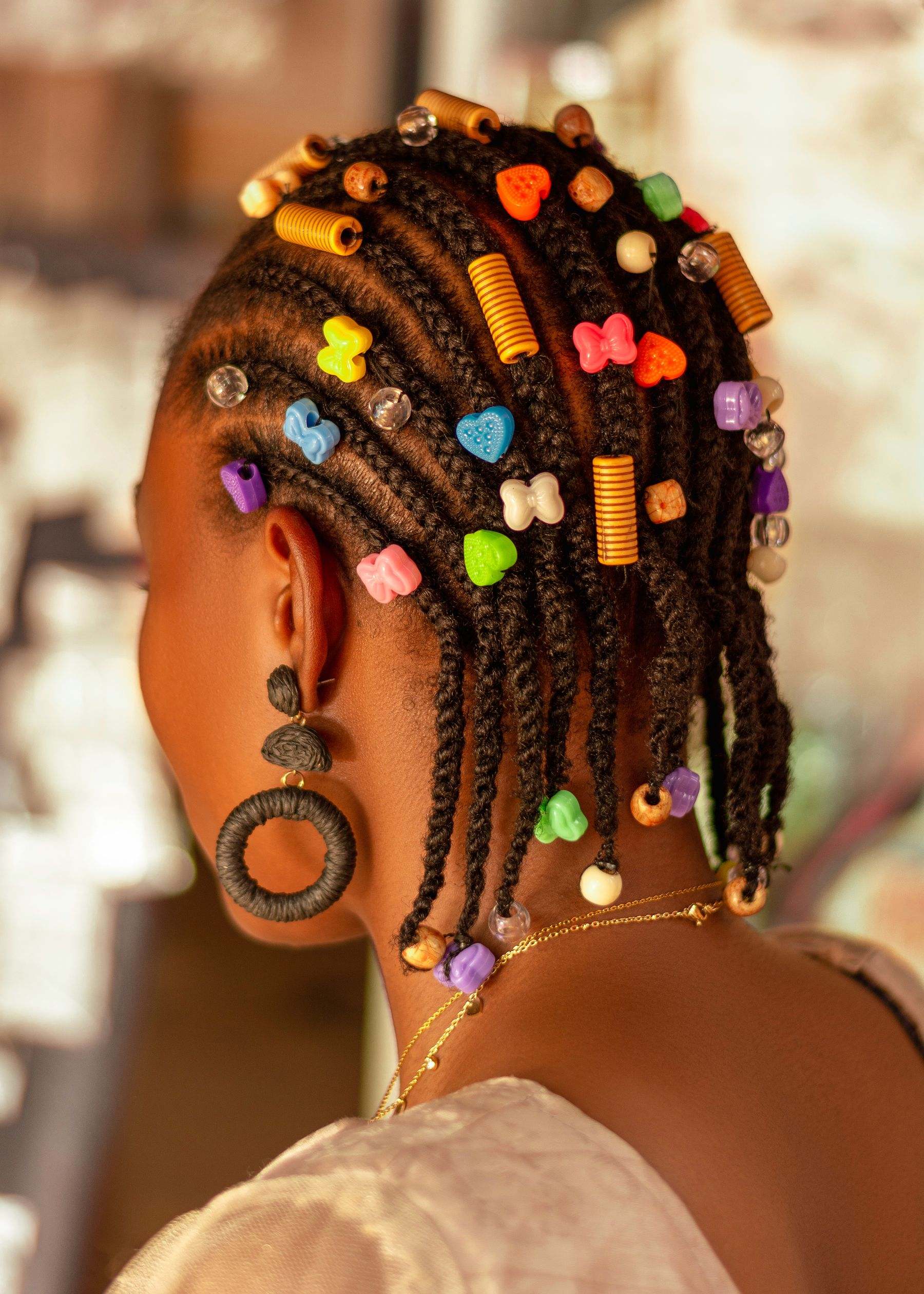 Cornrows seen from behind, finished with colourful beads and cuffs